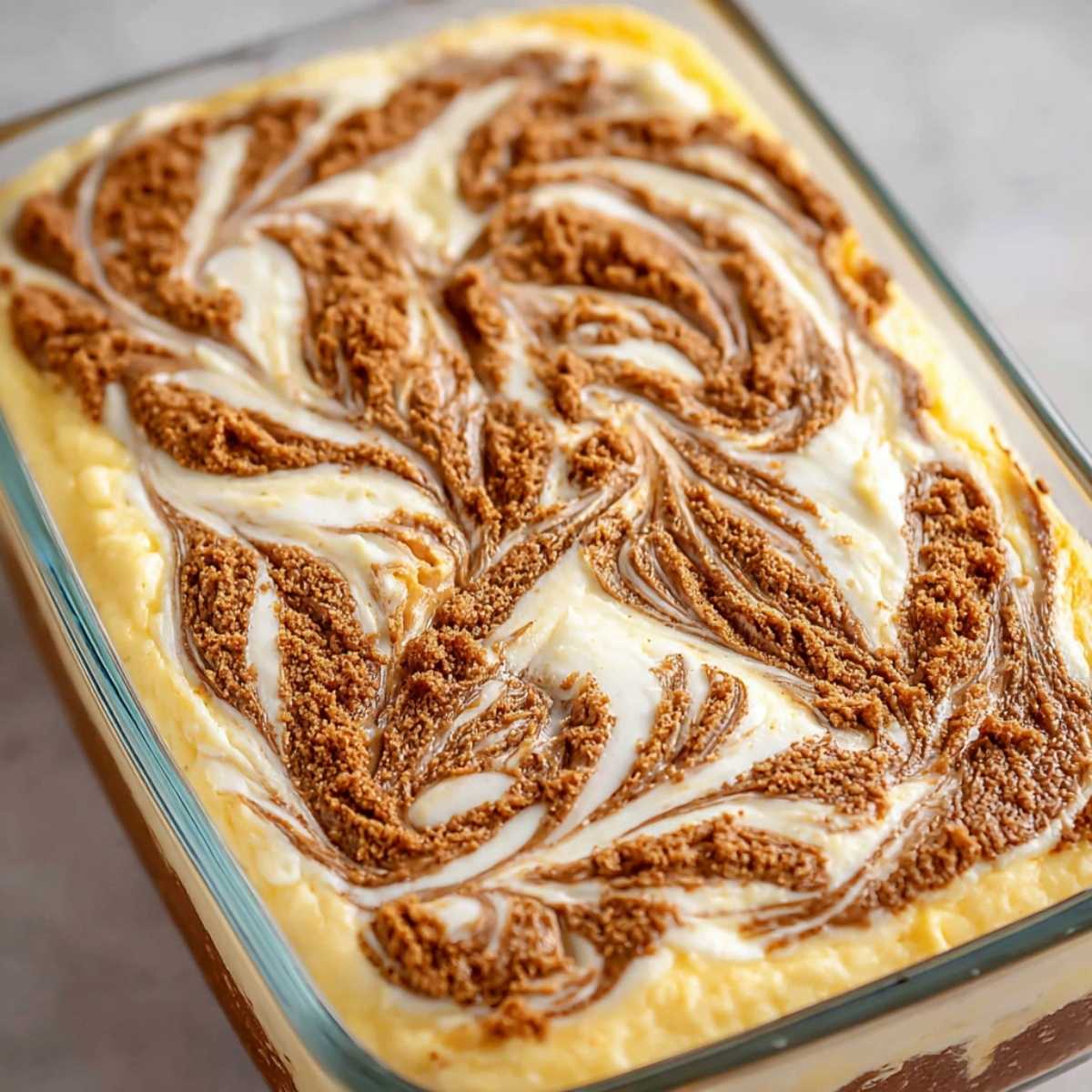 Easy Cinnamon Roll Cake 11 Close-up of Cinnamon Roll Cake with thick cinnamon-brown sugar swirl and creamy vanilla glaze in a glass baking dish.