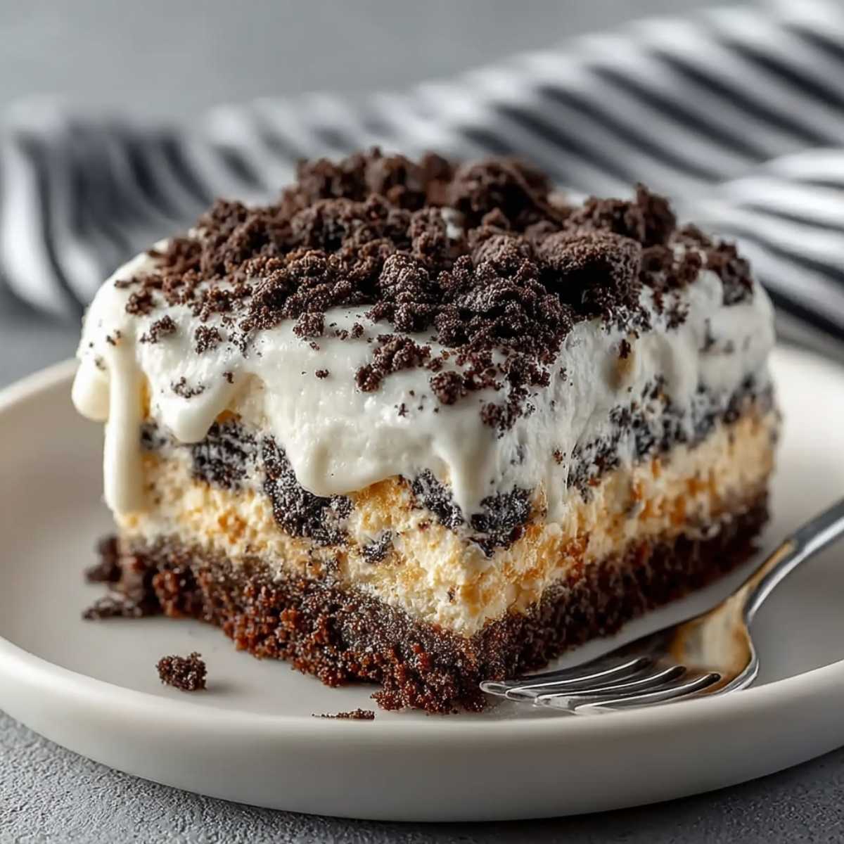 Close-up of Oreo dump cake showing creamy whipped topping, crushed Oreo layers, gooey condensed milk center, and rich chocolate base.