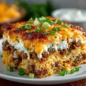 Easy Overnight Breakfast Casserole 21 Overnight breakfast casserole slice with golden melted cheese, sausage layers, and custardy eggs on a white plate