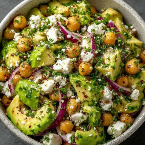 Quick Chickpea Feta Avocado Salad 1 Chickpea Feta Avocado Salad in a ceramic bowl with chunks of avocado, chickpeas, red onion, and crumbled feta cheese.